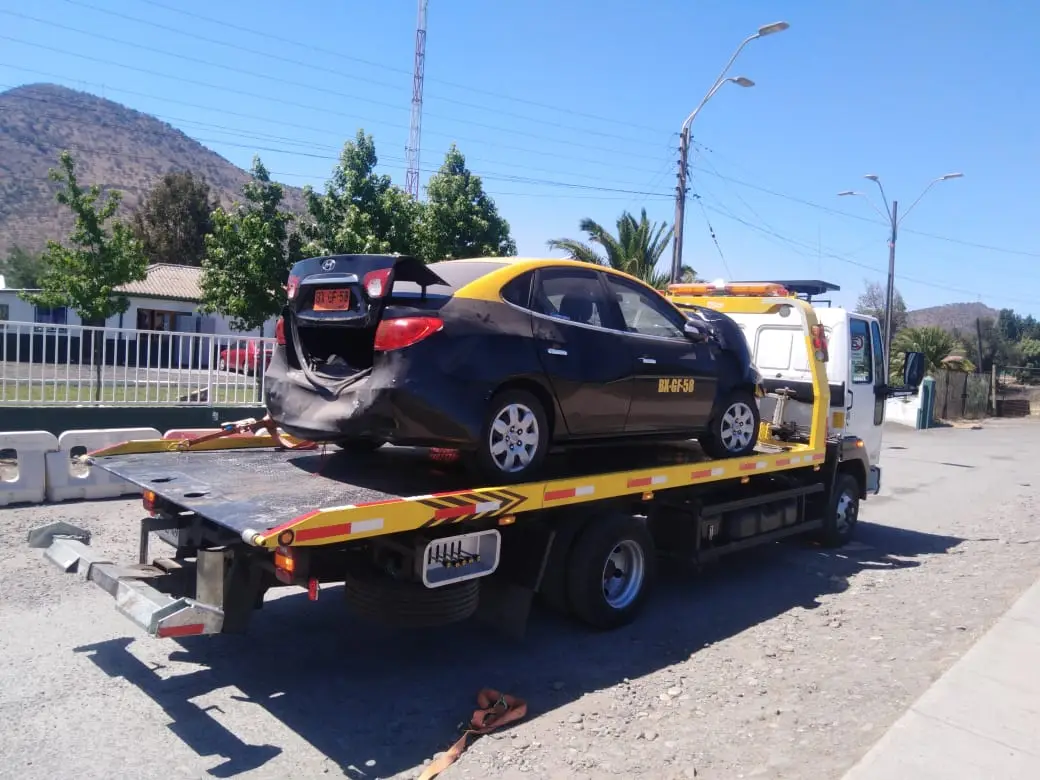 Grúa de plataforma de Grúas Cortes trasladando un auto en Santiago de noche